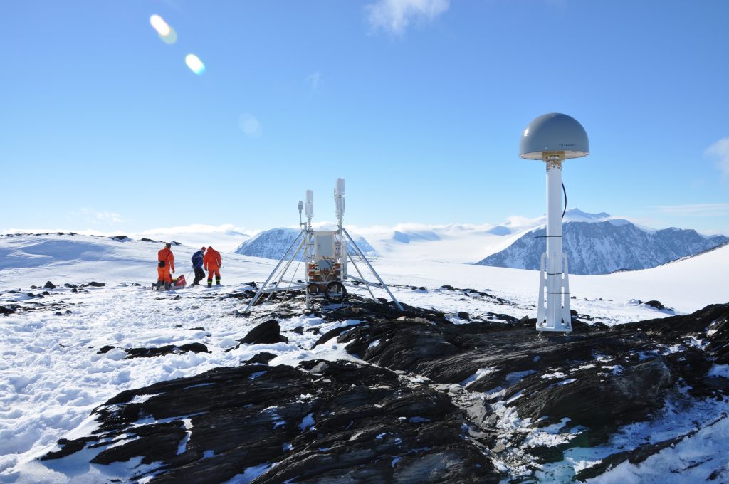 Scientists working near a rocky outcrop in Antarctica