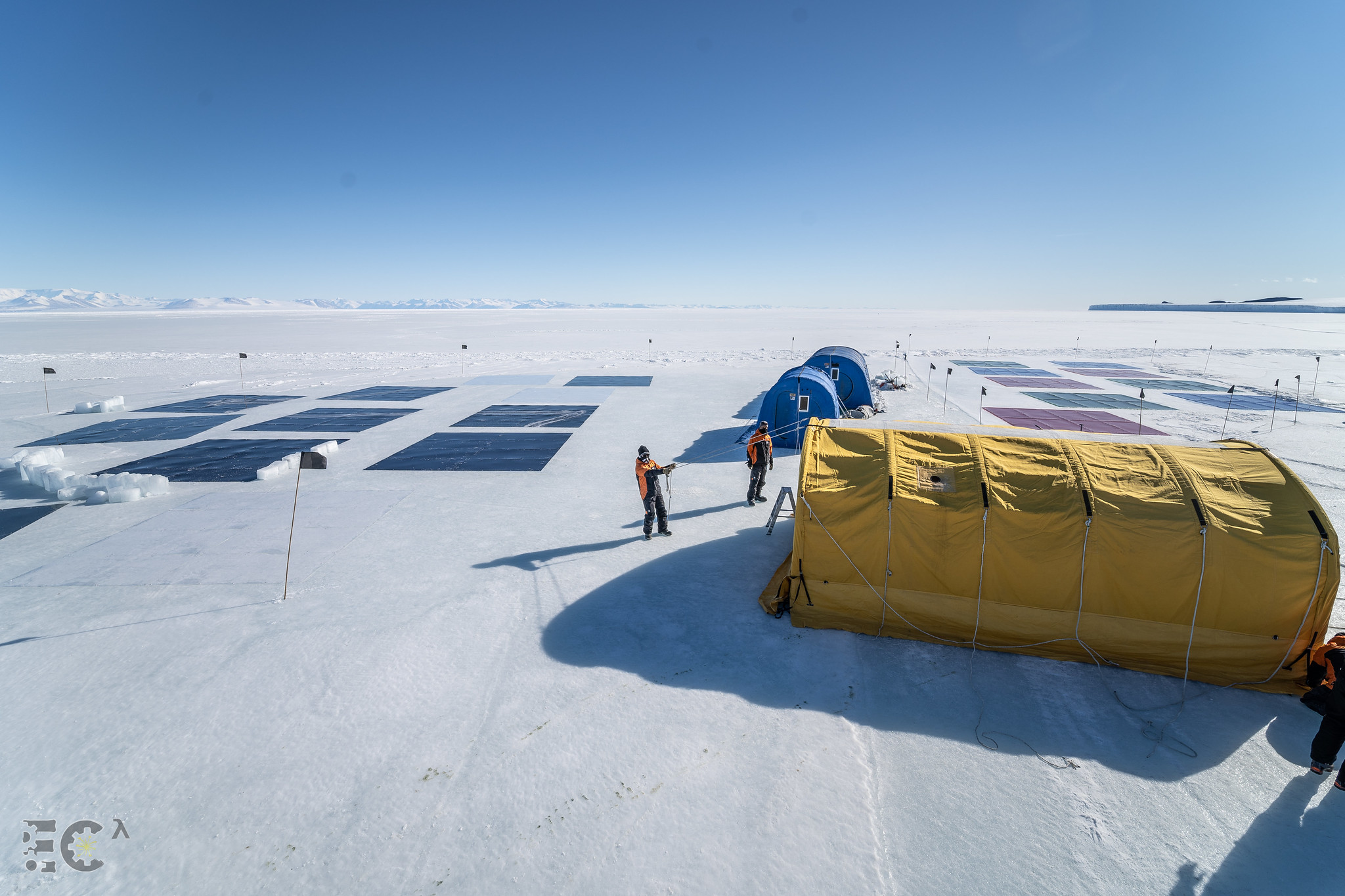 The team installing coloured Perspex panels – red, green, blue, grey and black – on the sea ice at Cape Evans in East Antarctica.