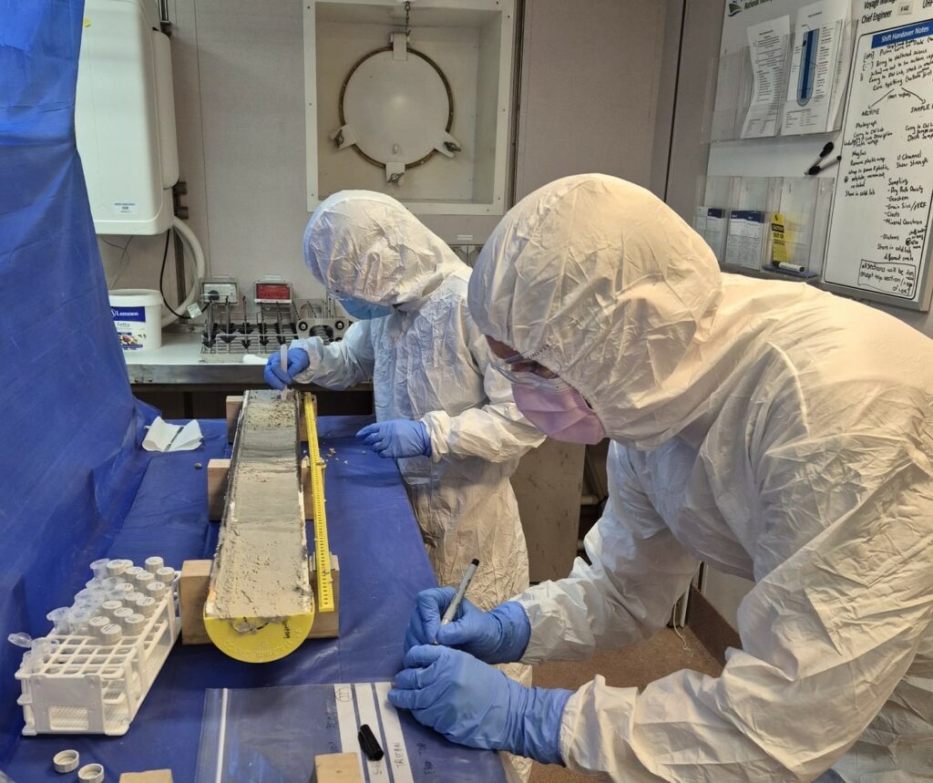Ana Gomes, Research Fellow (back) and Dr Tristan Cordier, Senior Researcher from NORCE (Norwegian Research Centre) conducting sedaDNA sampling from a Piston Core section (Image Credit: L. Armbrecht)