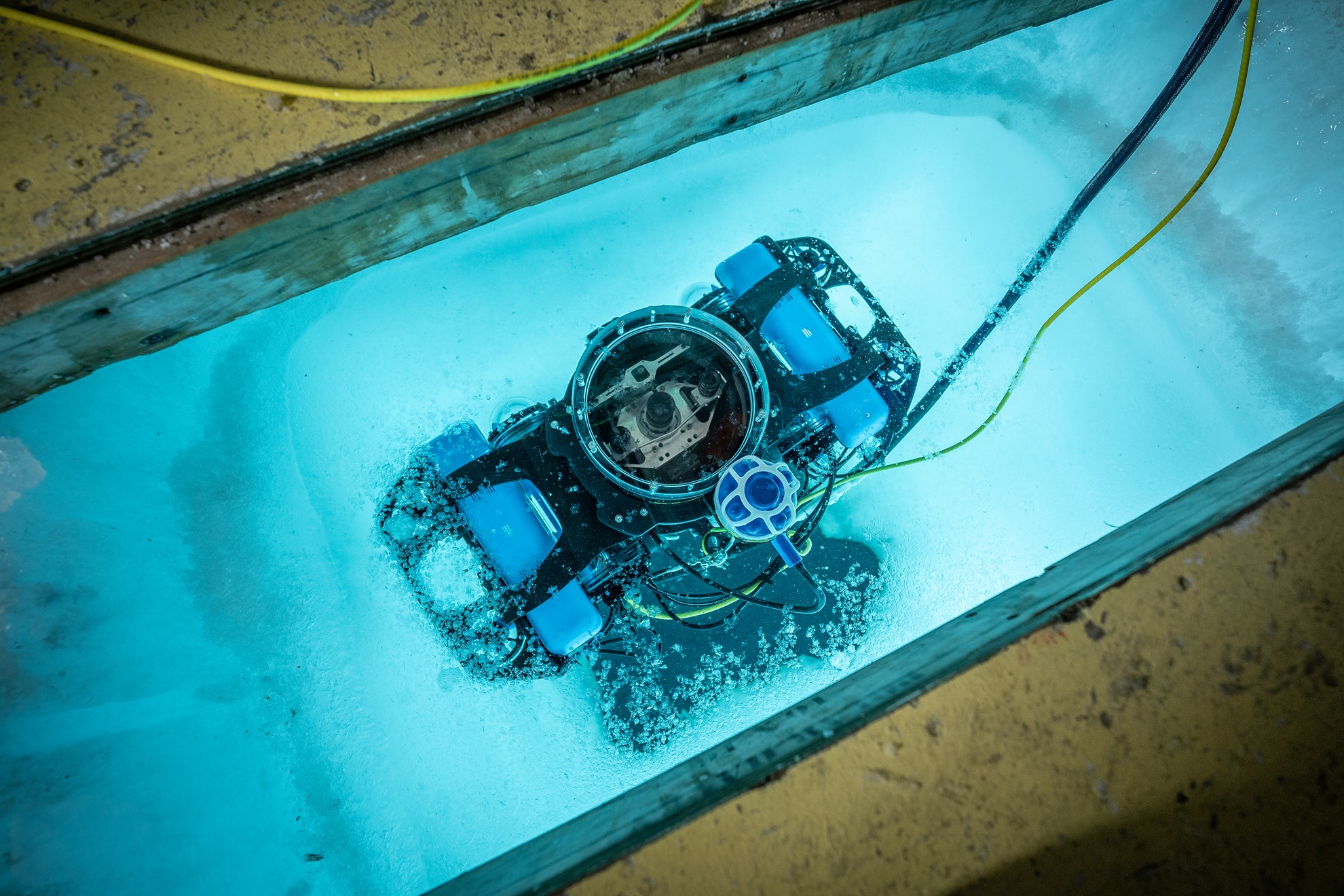 ‘HIcyBot’ being lowered through a hole cut in the sea ice. This specialised remotely operated vehicle (ROV) is used to study sea ice algae using underwater hyperspectral imaging. Credit: Emiliano Cimoli IMAS